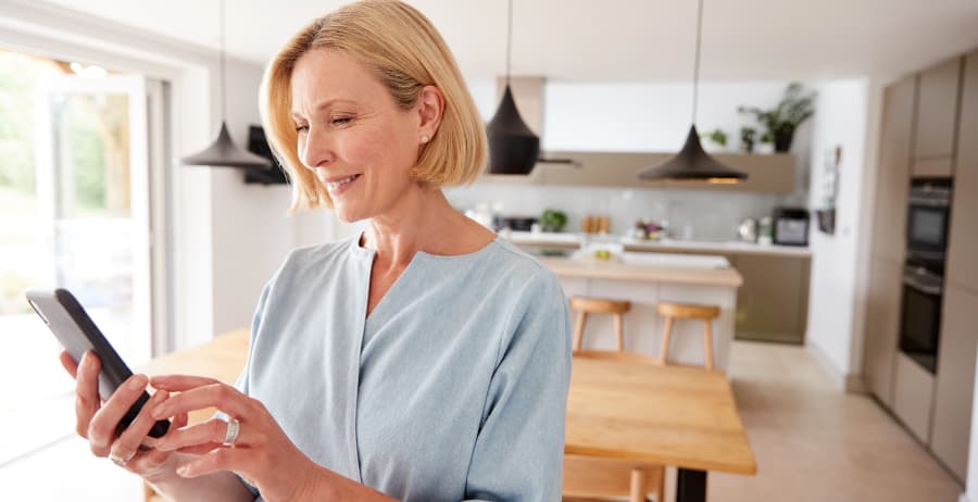 Resident with smartphone in a room filled with sunlight